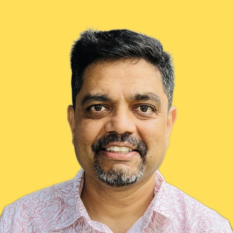 2026-09-26_AmericanBhau_LinkedIn-headshot-B-yellow-bg_v2